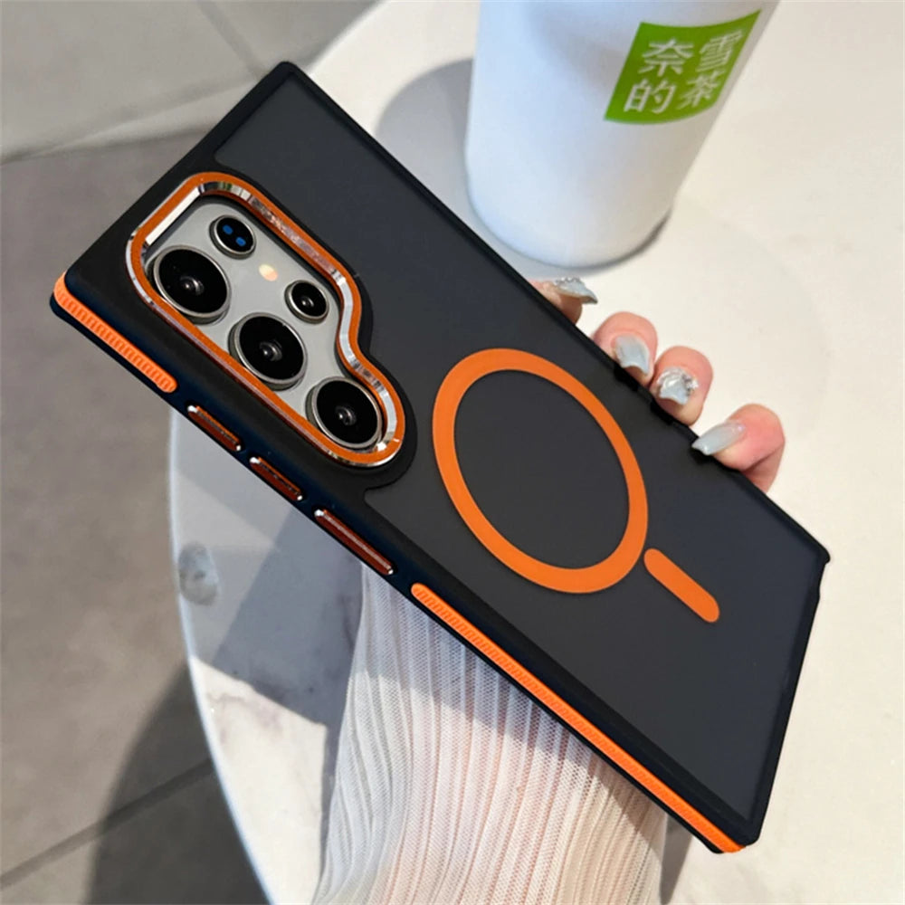 A person holding a Samsung Galaxy smartphone in a luxury matte magnetic black case with orange accents around the camera and edges.