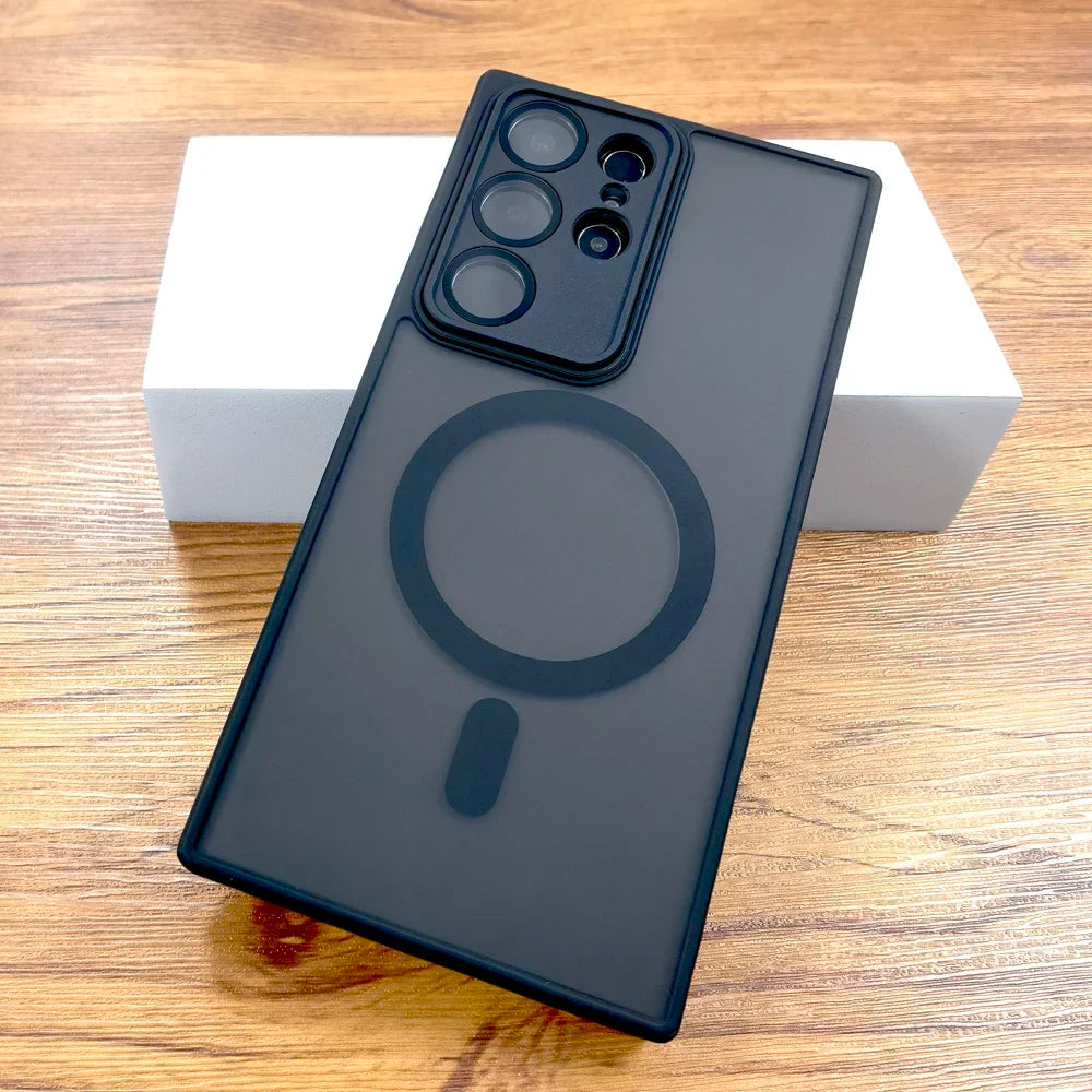 A gray matte case for Samsung Galaxy with a built-in circular magnetic charging pad, displayed on a wooden surface.