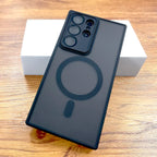 A gray matte case for Samsung Galaxy with a built-in circular magnetic charging pad, displayed on a wooden surface.