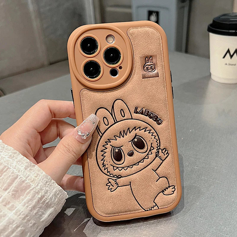 Phone case with cartoon design held by a hand on a table with a blurred background