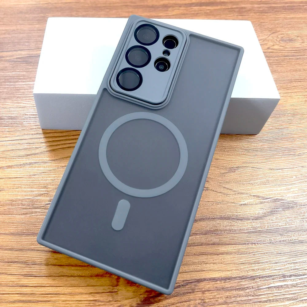 A gray matte case for Samsung Galaxy with a built-in circular magnetic charging pad, displayed on a wooden surface.